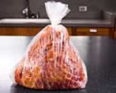 a plastic bag filled with food sitting on top of a counter next to a sink