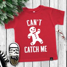 "CAN'T CATCH ME" Gingerbread Man Boy's Christmas T-shirt - Boys Christmas shirts The perfect boys Christmas shirt for the holidays!  Sweatshirt Color: Red, Forest Green, or Black Sizes: 6M, 12M, 18M, 24M, 2T, 3T, 4T, 5/6T Fabric: Cotton Blend Sweatshirt has our signature Sonrise State tag sewn in! Christmas Shirts Boys, Boy Christmas Shirts For Kids, Kids Christmas Tshirts Ideas, Toddler Christmas Shirts Boy, Funny Kids Christmas Shirts, Christmas T Shirt Design Ideas, Kids Christmas Shirt Ideas, Kids Christmas Shirts Vinyl, Boys Christmas Shirts