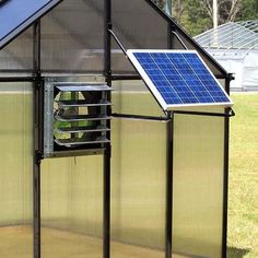 a small greenhouse with a solar panel on the roof and sidewalls that are open