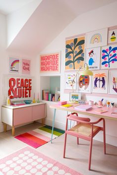 a pink desk with pictures on the wall