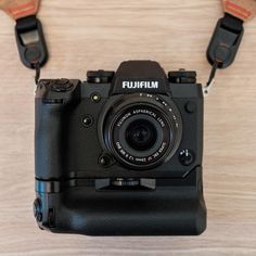 a black camera sitting on top of a wooden table