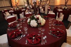 the table is set with red linens and silverware for an elegant wedding reception