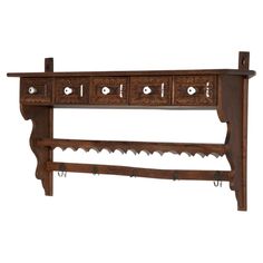 a wooden shelf with several drawers and hooks on the bottom one drawer is open to show keys