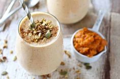 two glasses filled with smoothie and topped with nuts