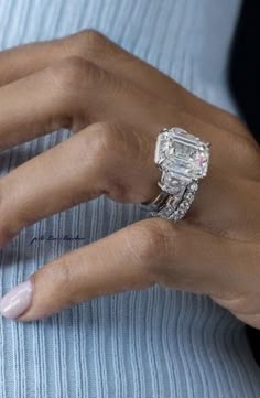 a woman's hand with a ring on it and an engagement band around her finger