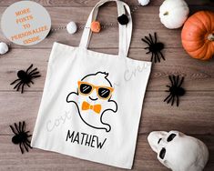 a white bag with an orange bow tie and sunglasses on it next to halloween decorations