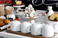 a table topped with white cups filled with desserts