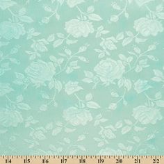 a ruler is next to a blue fabric with white flowers on it