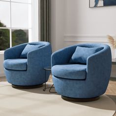 two blue chairs sitting next to each other on top of a rug in front of a window