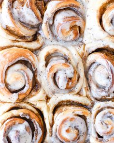 cinnamon rolls with icing sitting on top of each other in the middle of a pan