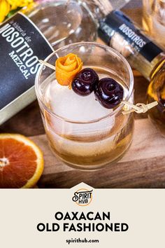 an old fashioned cocktail is garnished with olives