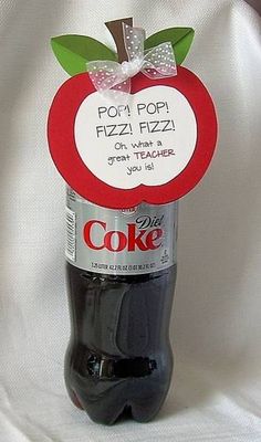 a bottle of coke with a red apple on top and a white ribbon around it