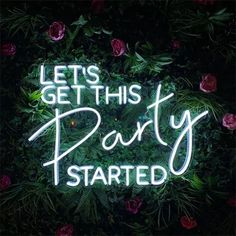 a neon sign that says let's get this party started in front of flowers