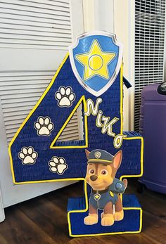 a blue and yellow number four shaped like a paw patrol dog