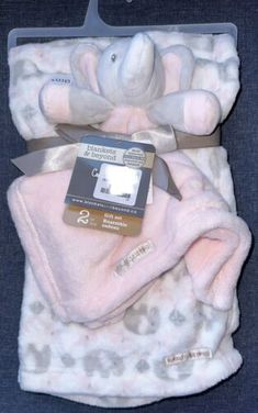 a white teddy bear laying on top of a blanket with a tag attached to it