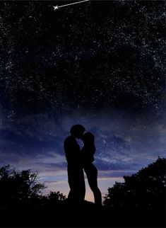 a couple kissing under the stars in the night sky