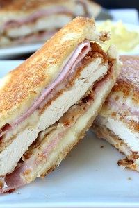 a close up of a sandwich on a plate with the words chicken crocon bleu grilled cheese