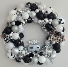 a christmas wreath with black and white ornaments