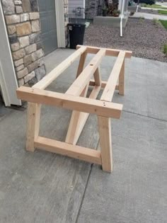 a wooden bench sitting on top of a sidewalk