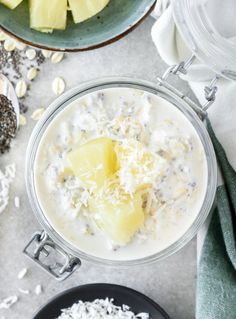 two bowls filled with oatmeal next to sliced pineapple