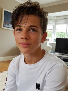 a young boy sitting on the floor in front of a tv