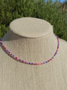 a necklace with multicolored beads on a mannequin's neckline