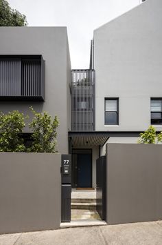 the entrance to an apartment building with grey walls and stairs leading up to it's second floor