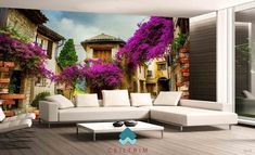 a living room with white furniture and purple flowers on the wall