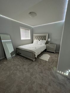 a bed room with a neatly made bed and a mirror