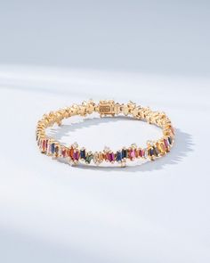 Experience the Bold Burst Rainbow Sapphire Tennis Bracelet, a striking creation that harmoniously blends 7.58 carats of rainbow sapphire baguettes with 2.12 carats of glistening baguette and round G VS diamonds. Each sapphire, cut into sleek baguettes, is set in 18k gold, showcasing a vibrant cascade of colors. Whether gracing a gala or elevating your everyday wardrobe, this tennis bracelet promises to be a treasured addition to your jewelry collection. Details 18k rose gold or yellow gold 7.58 carats of rainbow sapphire baguettes 1.68 carats of baguette white diamonds 0.44 carats of round white diamonds Bracelet measures 7 inches in length Box clasp with safety lock fastening 8.5mm length Ref: AKB366 Colored Tennis Bracelet, Luxury Multicolor Baguette Diamond Jewelry, Sapphire Tennis Bracelet, Diamonds Bracelet, Easy Doodles, Rainbow Sapphires, Doodles Drawings, Vs Diamond, Box Clasp