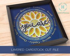 a wooden table with a blue and yellow frame on it that says you care, layered cardstock cut file