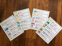 four spanish flash cards on a wooden surface with the words in different colors and font