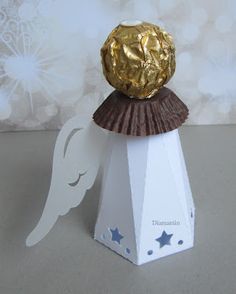 an ornament with a gold foiled ball on top and stars around it