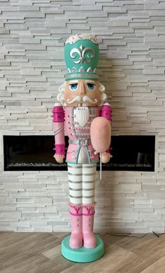 a wooden nutcracker standing in front of a fireplace with a pink and green balloon