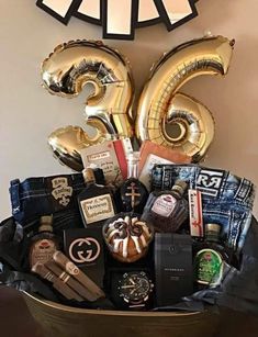 a large basket filled with lots of different types of items and balloons in front of a clock