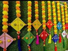 many colorful kites are hanging on the wall with tassels attached to them