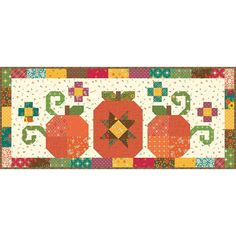 a quilted table runner with three pumpkins on the front and one in the middle