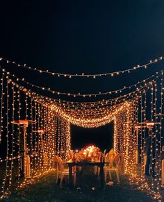 an outdoor dining area is lit up with fairy lights