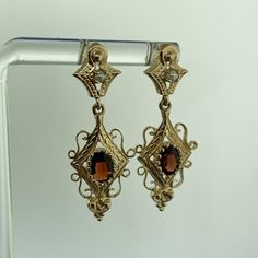 * Vintage 14K Yellow Gold Oval Garnet Seed Pearl Dangle Drop Earrings * Length: 1-7/16" * Width: 1/2" * Oval Garnets measure approximately 6.0 mm x 4.0 mm each * Seed Pearls measure approximately 1.90 mm each * Weight: 4.2 tgw * Marked: 14K * Fastening: Butterfly-NOT INCLUDED * Condition: As pictured. * G3407    Exported By ExportYourStore :) Elegant Oval Hallmarked Earrings, Victorian Oval Earrings For Anniversary, Yellow Gold Oval Filigree Earrings, Oval Yellow Gold Filigree Earrings, Oval Yellow Gold Earrings With Intricate Design, Victorian Oval Filigree Earrings, Victorian Oval Pierced Earrings, Victorian Filigree Oval Earrings, Elegant Stamped 14k Gold Dangle Earrings