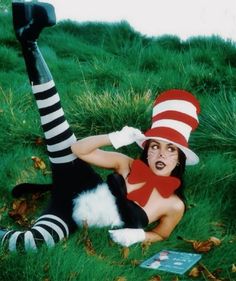 a woman laying on the ground wearing a cat in the hat costume with her legs spread out