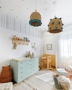 a baby's room with two hanging baskets above the crib and a dresser