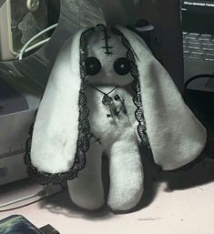 a white stuffed animal sitting on top of a desk