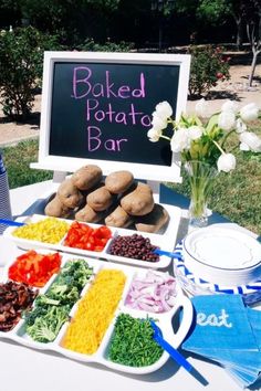 a table topped with plates filled with different types of food next to a sign that says baked potato bar