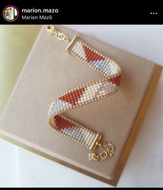 a pair of beaded bracelets sitting on top of a box next to each other