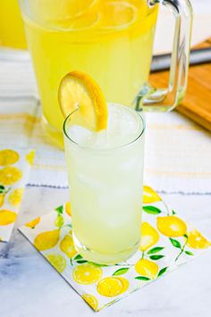 two glasses filled with lemonade sitting on top of a table