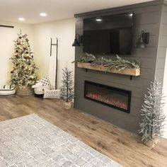 a living room with a fireplace and christmas tree in the corner on the far wall