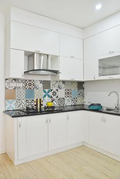 a kitchen with white cabinets and black counter tops