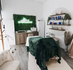 a room with white walls and green plants on the wall, including a bed covered in a blanket