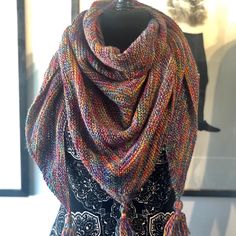 a multicolored knitted scarf with tassels hanging from it's sides