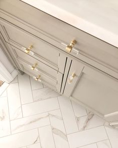 an overhead view of a white kitchen with gold hardware